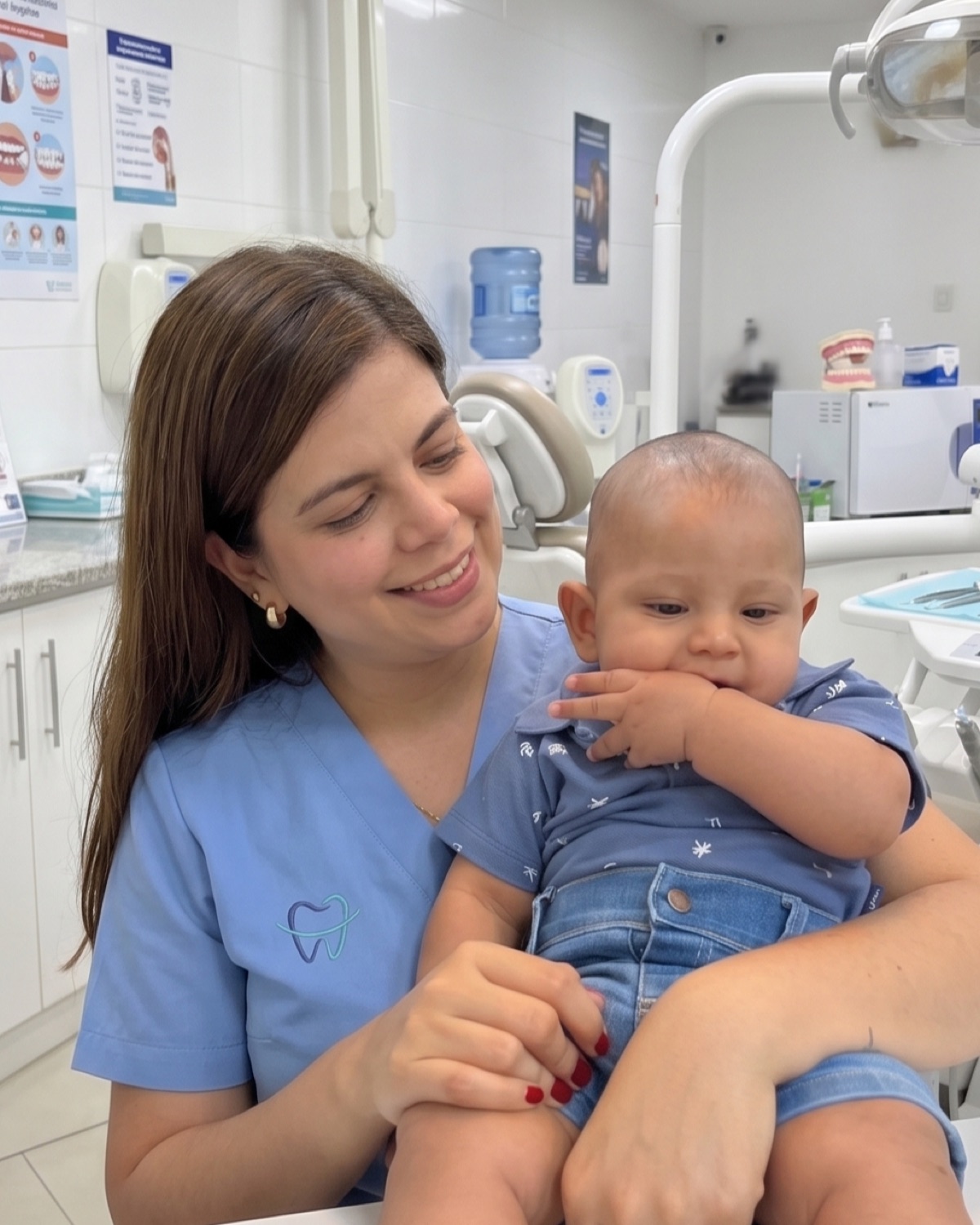 Dra. Kelly Palacio ortodoncista sosteniendo un bebé en su consultorio de Bogotá — atención pediátrica con calidez